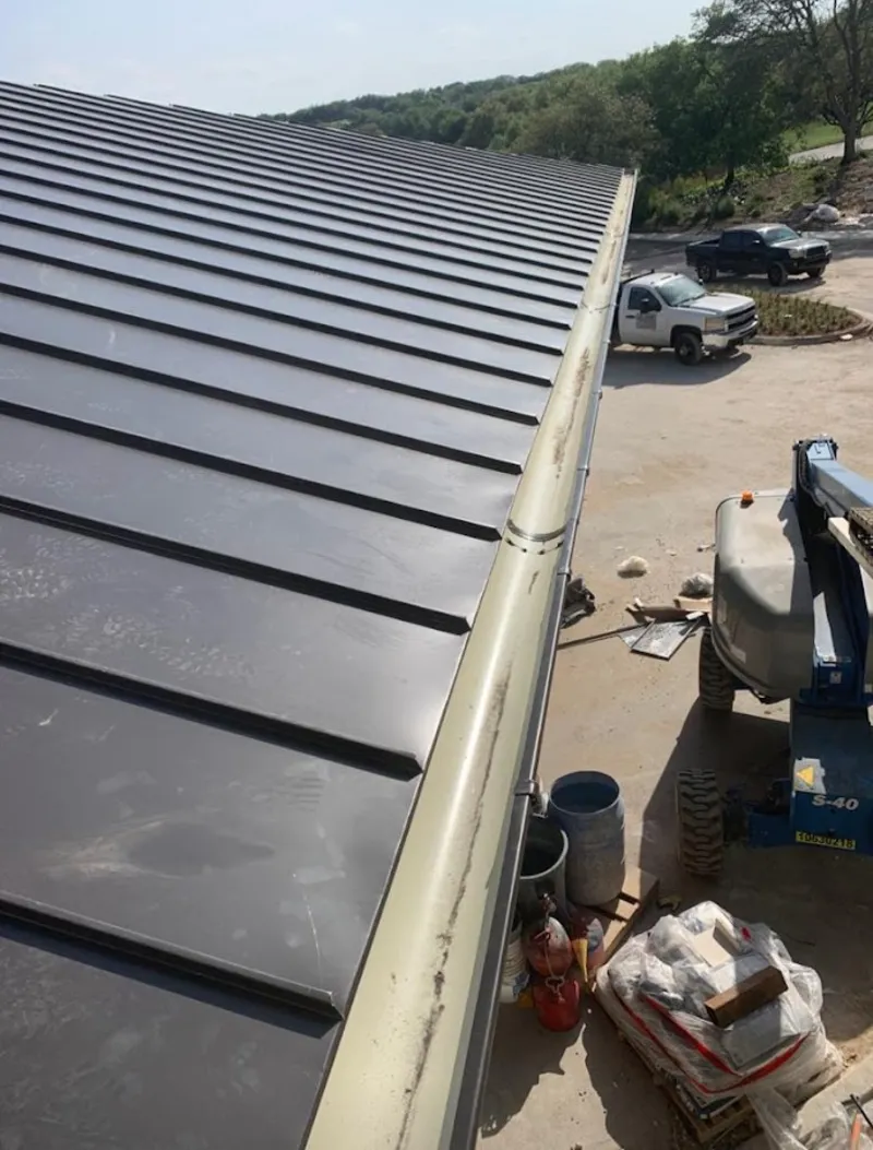 Standing seam panel and gutter detail on a metal roofing jobsite in Camden